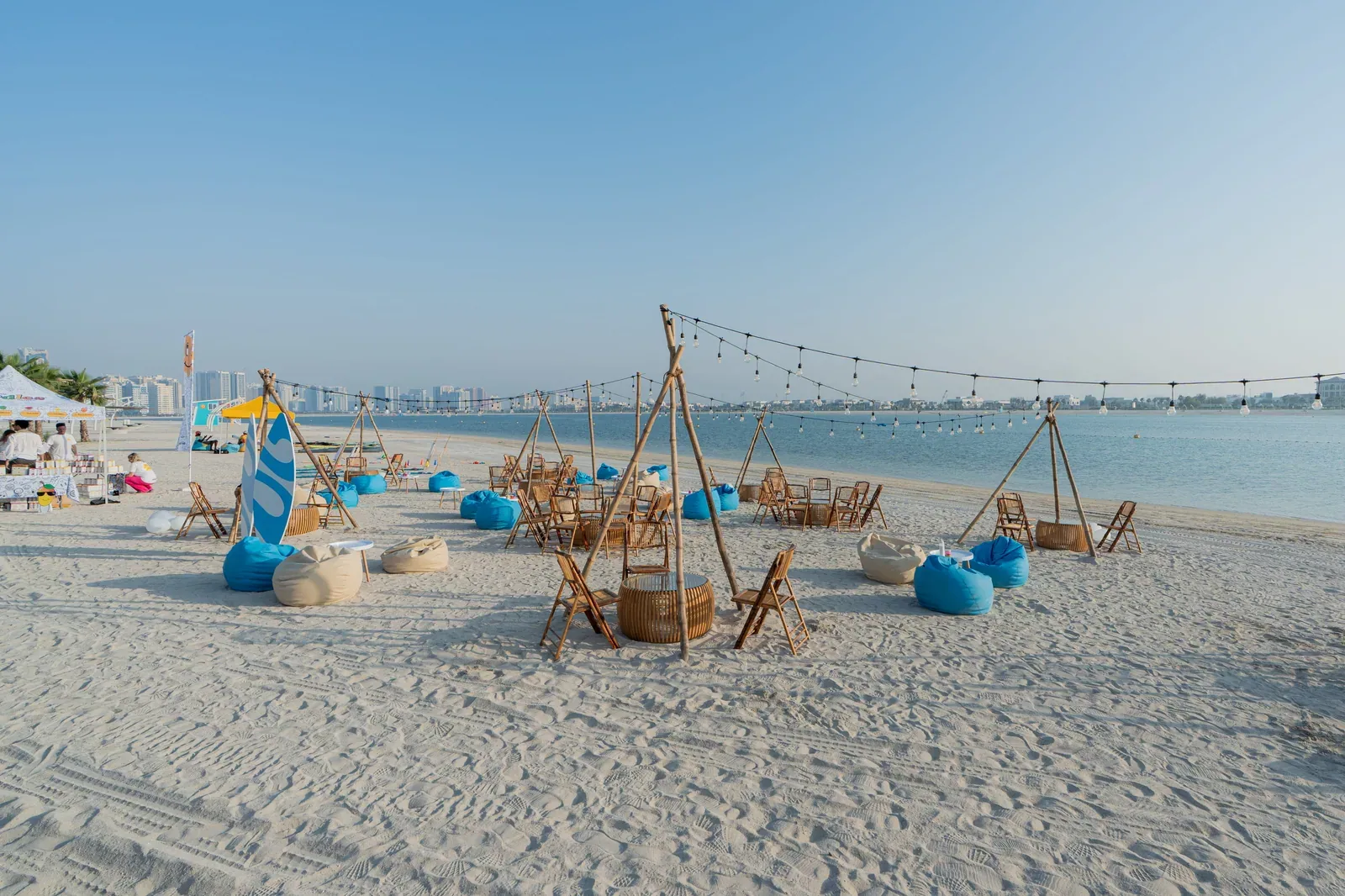Khor Al Mamzar’s sandy waterfront with chairs and string lights for the opening event
