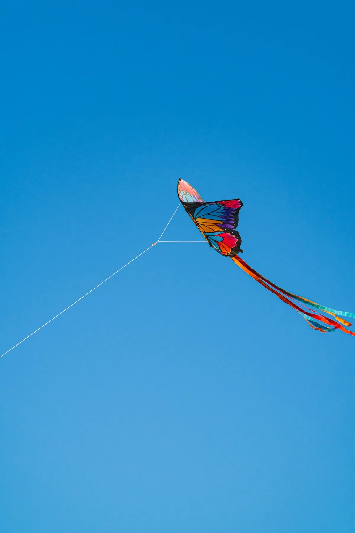 A colourful butterfly kite flying against a clear blue sky