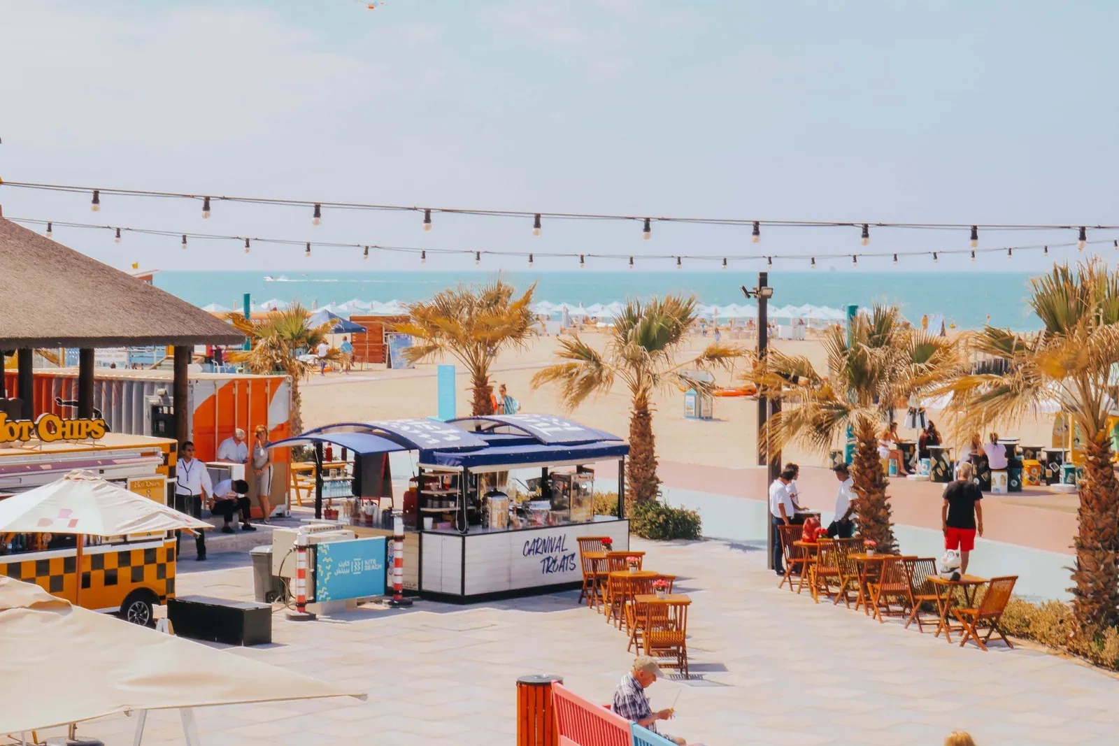 Food kiosks and outdoor seating along Kite Beach’s palm-lined pedestrian area