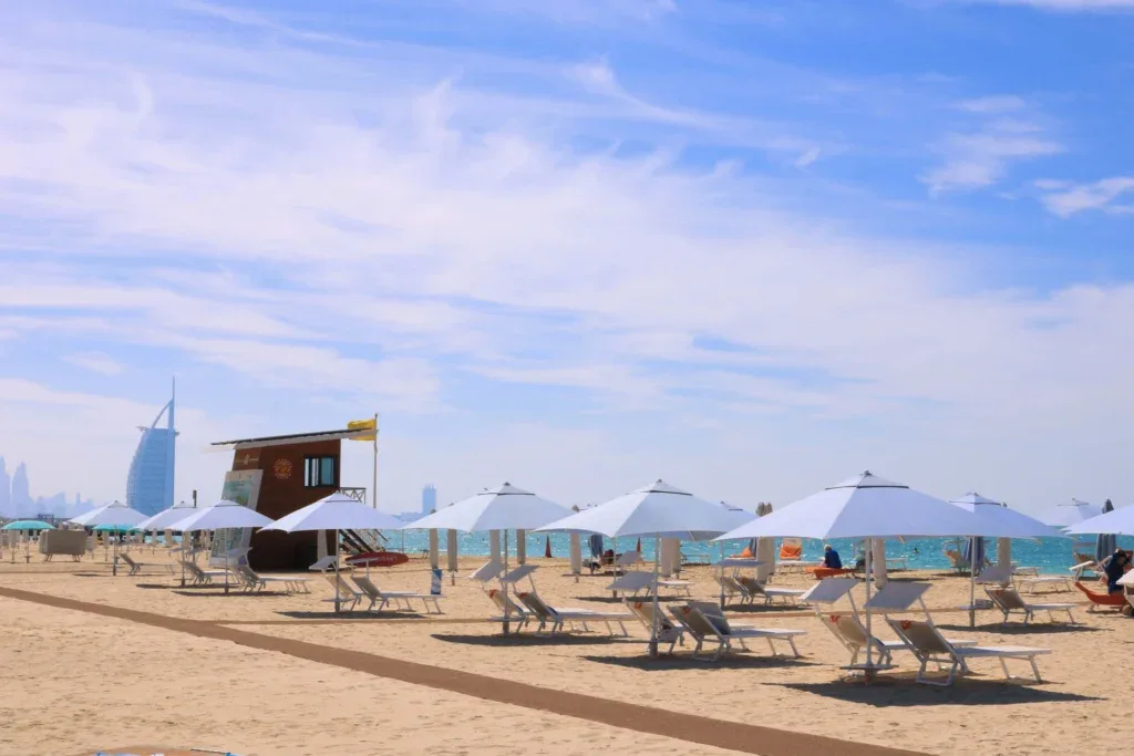 Sun loungers and umbrellas on Kite Beach, with Burj Al Arab in the distance